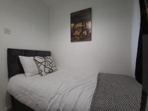 a bedroom with a bed with a picture on the wall at Newly Refurbished Home in Bradley Stoke, near Cribbs Causeway, Bristol, for Long Stays, Group Stays, Contractors, Sleeps up to 7 guests, Free Parking!! in Bristol