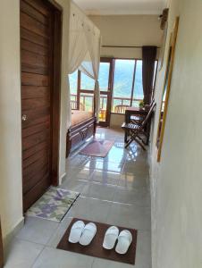 a room with a door and two white slippers on the floor at Made Oka Homestay and Warung in Munduk