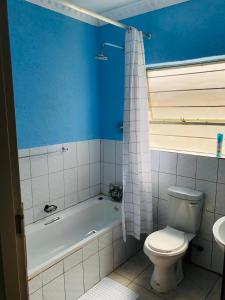 ein Badezimmer mit einer Badewanne, einem WC und einem Waschbecken in der Unterkunft Zinathi Lodge in Lebowakgomo