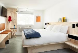 a bedroom with a large white bed and a window at Field Station Moab in Moab