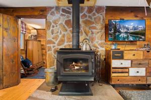 Una chimenea en una habitación con una pared de piedra. en Lil' Frying Pan Cabin, en Golden