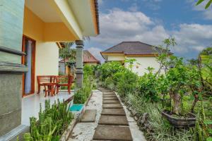 un jardín fuera de una casa con un camino en The Salang Guest House en Nusa Penida