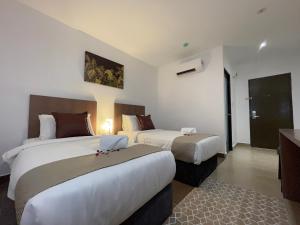 a hotel room with two beds with a laptop on it at DSH Hotel in Kuantan +22 photos