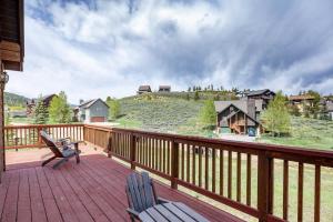 a deck with two chairs and a view of a house at Overlook in Granby