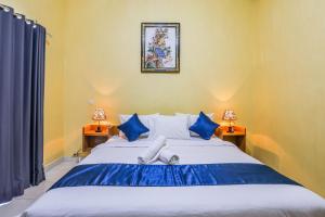ein Schlafzimmer mit einem großen Bett mit blauen Kissen in der Unterkunft The Salang Guest House in Nusa Penida