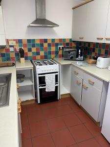 a kitchen with a stove and a tile floor at Newly Refurbished Home in Bradley Stoke, near Cribbs Causeway, Bristol, for Long Stays, Group Stays, Contractors, Sleeps up to 7 guests, Free Parking!! in Bristol