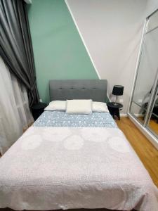 une chambre avec un lit avec un mur bleu dans l'établissement KL EAST RIDGE RARA SUITE HOMESTAY, à Kuala Lumpur 27 autres photos