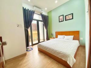 a bedroom with a bed and a large window at Moon's House Homestay Quy Nhơn in Quy Nhon