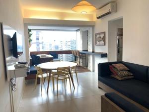 uma sala de estar com um sofá e uma mesa com cadeiras em Real Apartments 254 - Barramares flat 2 quartos de luxo com vista espetacular no Rio de Janeiro