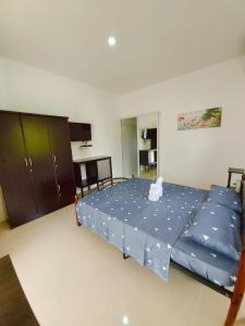 a bedroom with a large bed with blue sheets at UB HOME in Dauis