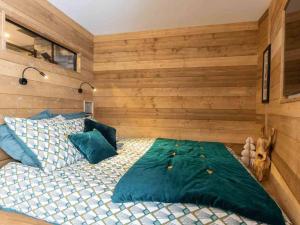 a bedroom with a large bed and wooden walls at Appartement Valmorel, 2 pièces, 3 personnes - FR-1-291-888 in Valmorel