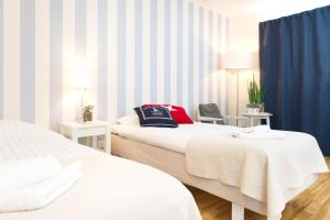 a hotel room with two beds and a chair at Attendo Park Hotell in Huddinge