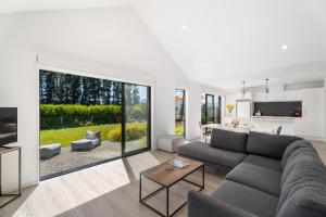 ein Wohnzimmer mit einem Sofa und einem Tisch in der Unterkunft Northlake Hideaway - Wanaka Holiday Home in Wanaka