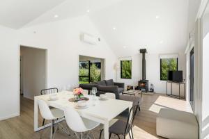 a living room with a white table and chairs at Northlake Hideaway - Wanaka Holiday Home in Wanaka
