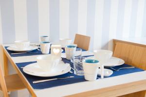 a table with white cups and saucers on it at Attendo Park Hotell in Huddinge
