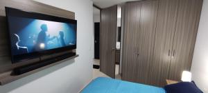 1 dormitorio con TV de pantalla plana en la pared en Apartaestudio en Armenia, en Armenia