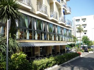 un edificio con sombrillas blancas a su lado en Blu Star Hotel, en Gabicce Mare