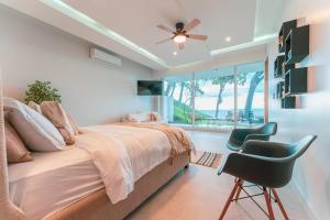 a bedroom with a bed and a chair and a window at Childhood dream house #1 - Private Pool Ocean View in Las Mantas