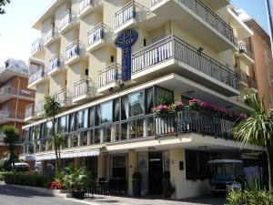 un grand bâtiment blanc avec des balcons et des plantes dans l'établissement Blu Star Hotel, à Gabicce Mare