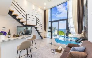 a living room with a staircase and a swimming pool at Yolo Spa Pension in Gangneung