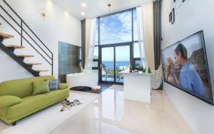 uma sala de estar com um sofá verde e uma televisão de ecrã grande em Yolo Spa Pension em Gangneung