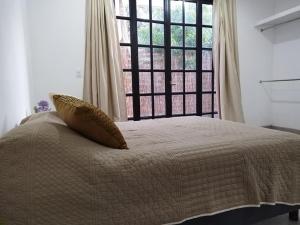 a bedroom with a bed with a large window at CASA MANGO 3 Amplio departamento in Río Verde