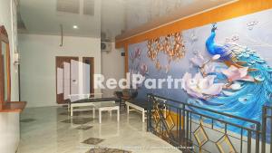 Cette chambre est dotée d'une fresque murale représentant un paon. dans l'établissement RedDoorz near Lippo Mall Yogyakarta 2, à Yogyakarta