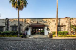 an entrance to a building with a palm tree at Ex Hacienda Santa Cecilia in Cuernavaca