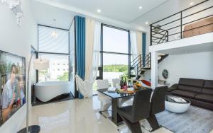 een woonkamer met een bad en een tafel en stoelen bij Yolo Spa Pension in Gangneung