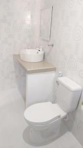 a bathroom with a white toilet and a sink at UB HOME in Dauis +12 photos