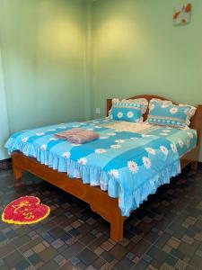 a bedroom with a bed with a blue comforter at Wangthong Beach Resort in Laem Sing