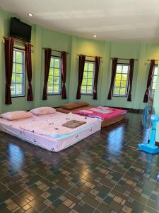 two beds in a room with green walls and windows at Wangthong Beach Resort in Laem Sing