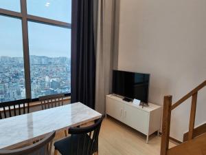 a living room with a table and a television at JSM Studio Hongdae in Seoul