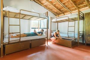2 personnes sont assises dans une chambre avec des lits superposés dans l'établissement SPACELAND Mandrem, à Mandrem