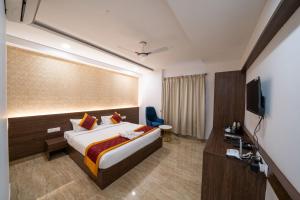 een hotelkamer met een bed en een televisie bij Bangalore Times in Bangalore