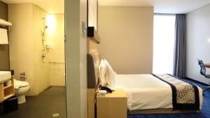 Postel nebo postele na pokoji v ubytování AI Hotel Jakarta Thamrin