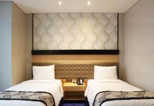 Postel nebo postele na pokoji v ubytování AI Hotel Jakarta Thamrin
