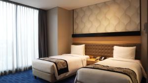 Postel nebo postele na pokoji v ubytování AI Hotel Jakarta Thamrin