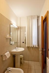 a white bathroom with a sink and a mirror at Hotel Idania in Bardolino