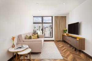 a living room with a couch and a tv at Shama Central in Hong Kong