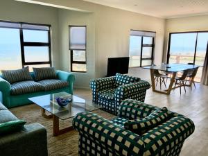a living room with couches and a table and chairs at Ocean view, Swakopmund, 3-bedroomed apartment in Swakopmund