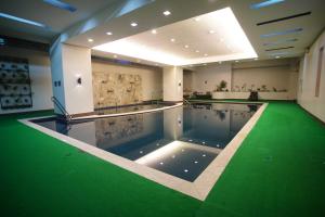 a swimming pool with a green floor in a building at Millenia Suites Cozy Studio Unit 3003 in Manila