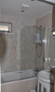 La salle de bains est pourvue d'une douche, d'une baignoire et d'un lavabo. dans l'établissement Dunlin 3 - The Cove, à Brixham