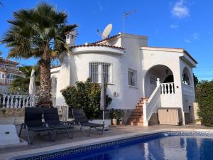 une maison avec un palmier et une piscine dans l'établissement Beautiful holiday home in Ciudad Quesada with private pool, à Ciudad Quesada