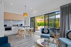 a kitchen and living room with a table and chairs at Kotuku Apartment - Kaiteriteri Holiday Unit in Kaiteriteri