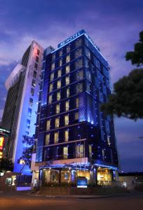 雅加達的住宿－AI Hotel Jakarta Thamrin，一座酒店大楼,晚上有蓝色的灯光