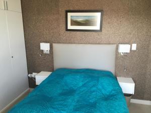 Un dormitorio con una cama con una manta azul encima. en Ocean view, Swakopmund, 3-bedroomed apartment, en Swakopmund