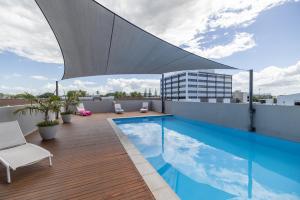 a rooftop patio with a swimming pool on a building at Aligned Corporate Residences Mackay in Mackay