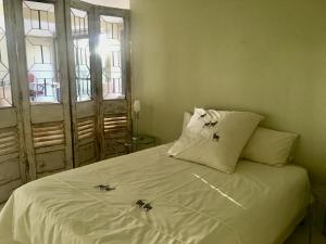 a bedroom with a white bed with two spiders on it at Klein Windhoek Garden flat in Windhoek