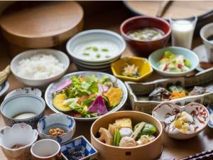 Yukemuri no Yado Inazumi Onsen في Yuzawa: طاولة مليئة بالأطعمة والأرز